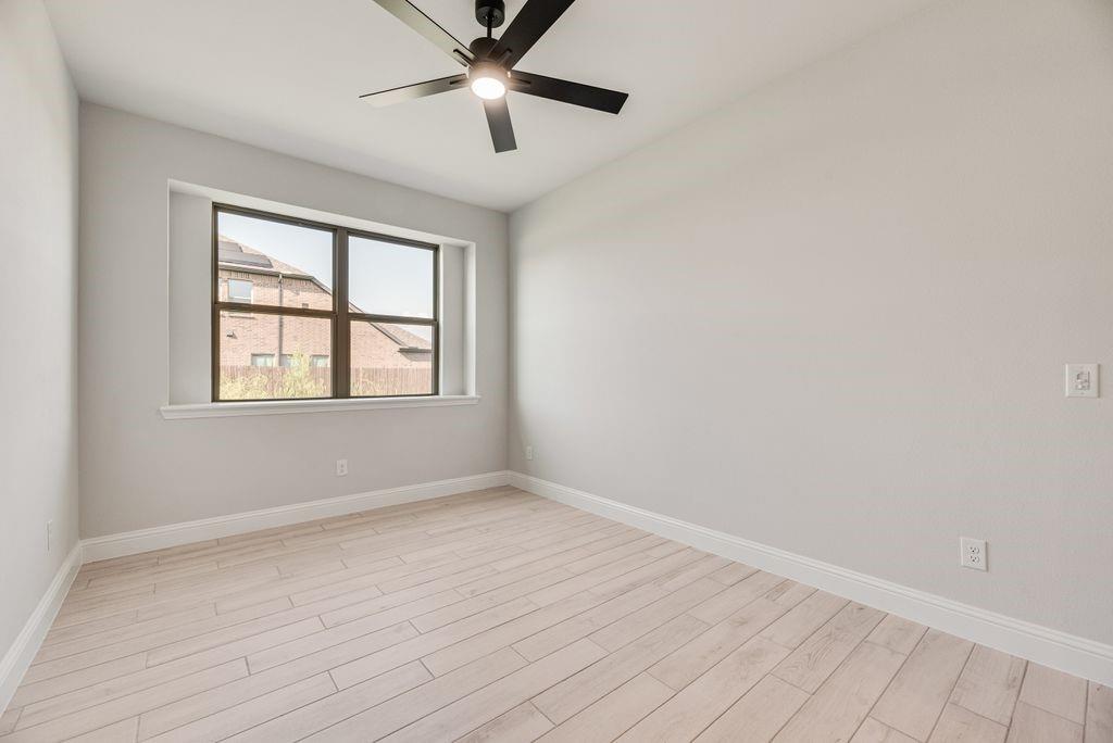 597 MB's Way Pilot Point, TX 76258 - Photo 12 of 34 an empty room with wooden floor ceiling fan and windows