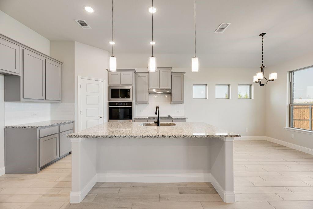 597 MB's Way Pilot Point, TX 76258 - Photo 17 of 34 a large kitchen with kitchen island a stove a center island a counter space a sink and a window