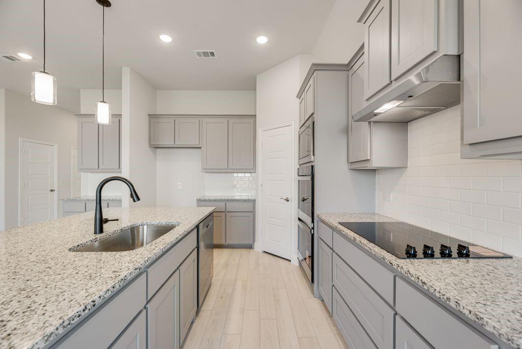 597 MB's Way Pilot Point, TX 76258 - Photo 18 of 34 a kitchen with stainless steel appliances granite countertop a sink a stove and a wooden floors
