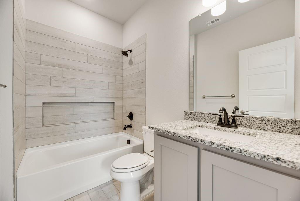 597 MB's Way Pilot Point, TX 76258 - Photo 32 of 34 a bathroom with a granite countertop bathtub sink vanity mirror and toilet
