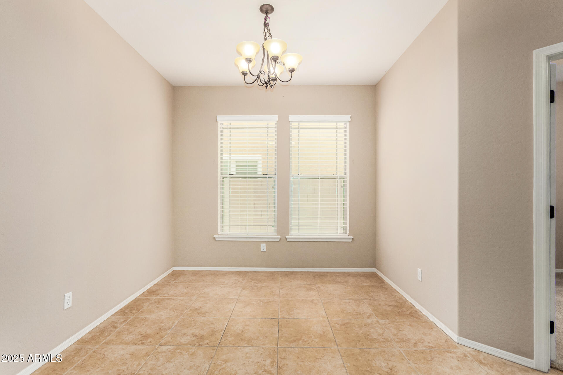 3540 East Mesquite Street Gilbert, AZ 85296 - Photo 11 of 55 an empty room with a chandelier fan and windows