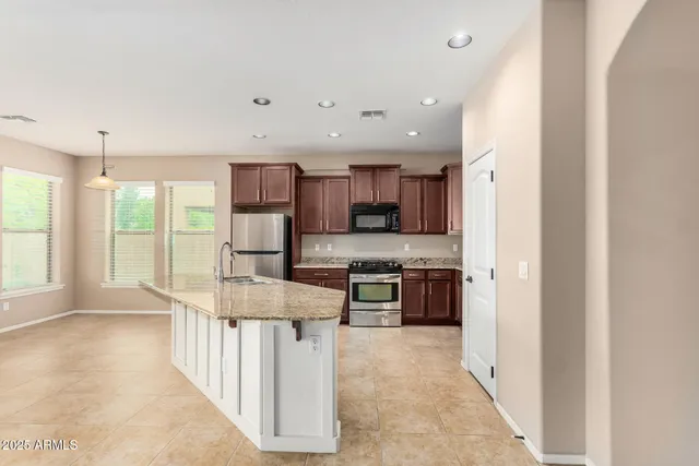 a open kitchen with stainless steel appliances granite countertop a refrigerator oven stove a sink and a dining table with the view
