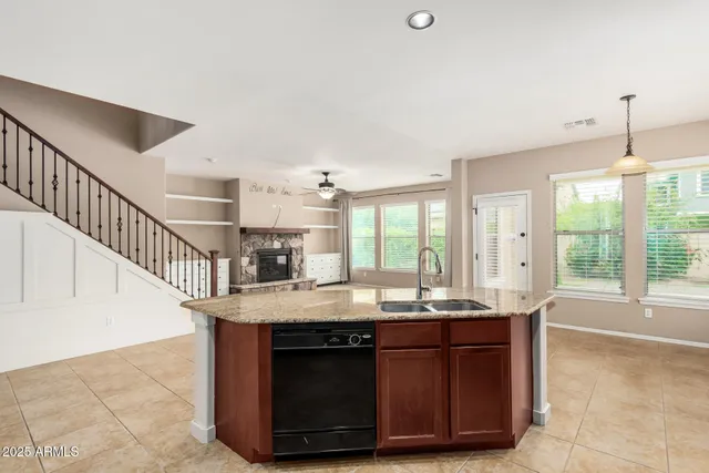 a kitchen with kitchen island granite countertop a sink and a stove