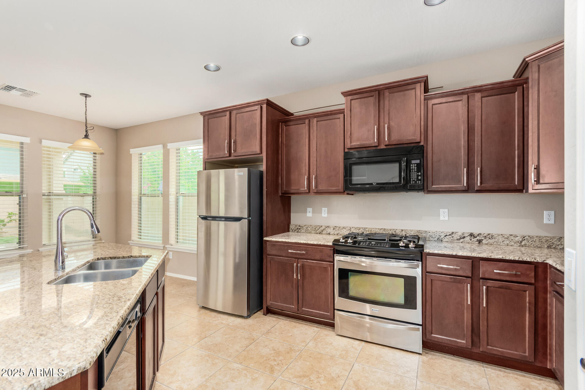 3540 East Mesquite Street Gilbert, AZ 85296 - Photo 23 of 55 a kitchen with stainless steel appliances granite countertop a stove refrigerator and microwave