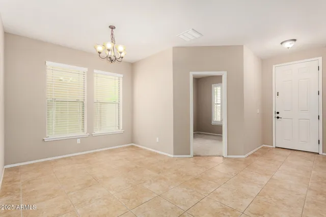 an empty room with chandelier and windows