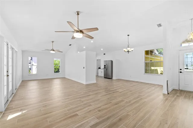 a view of an empty room with window and wooden floor
