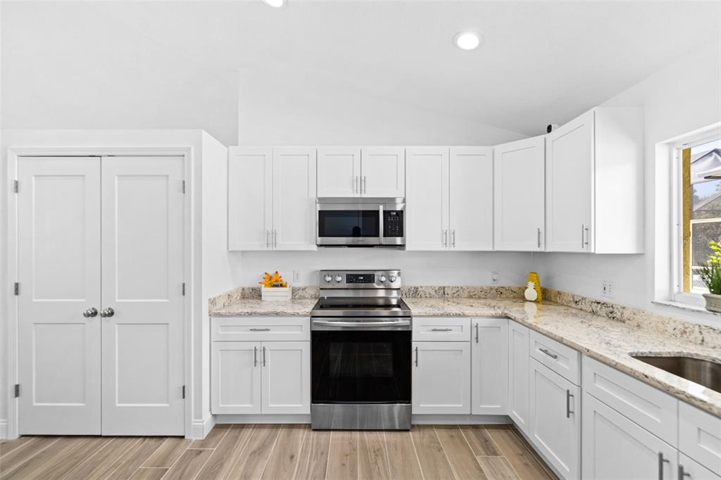 26 Marjorie Trail Ormond Beach, FL 32174 - Photo 9 of 30 a kitchen with granite countertop white cabinets and white appliances