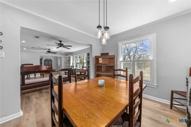 a dining room with furniture a chandelier and wooden floor