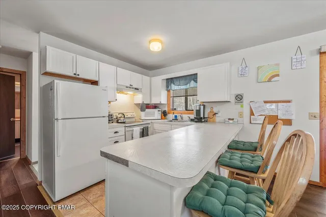 a kitchen with kitchen island a refrigerator and a sink