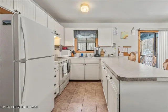 a large white kitchen with a large window