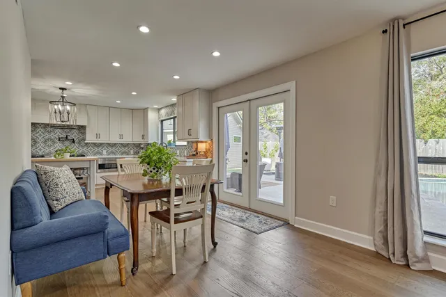 a kitchen with granite countertop a refrigerator oven a sink dishwasher and white cabinets with wooden floor