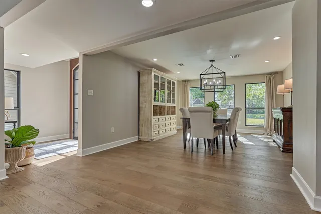 a dining room with furniture a chandelier and wooden floor