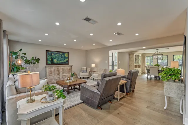 a living room with furniture a rug and a view of kitchen