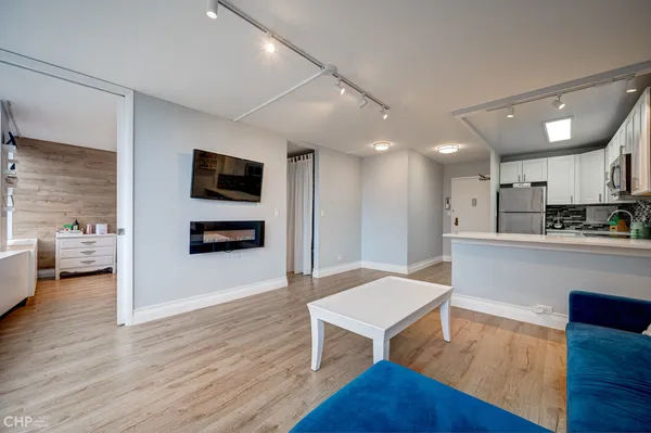 a living room with stainless steel appliances kitchen island granite countertop furniture wooden floor and a view of kitchen