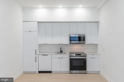 a kitchen with white cabinets and stainless steel appliances