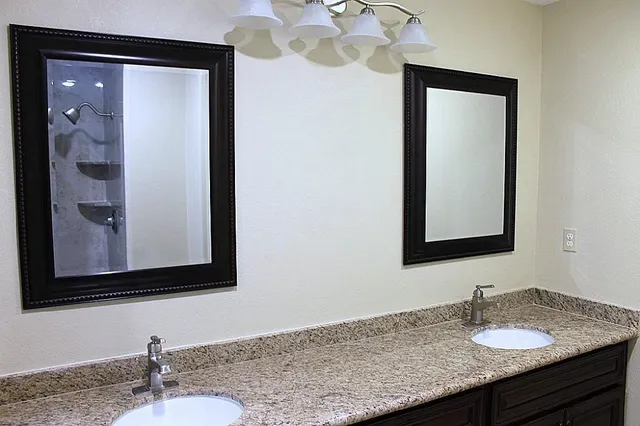 a bathroom with a granite countertop sink and a mirror
