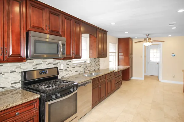 a kitchen with stainless steel appliances wooden cabinets and a stove top oven