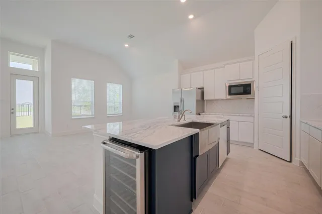 a kitchen with a sink dishwasher a stove and a refrigerator with wooden floor