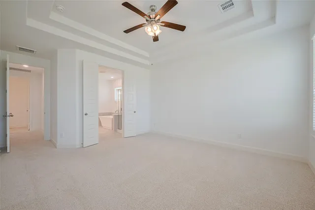 an empty room with closet and a ceiling fan