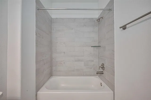 a white bath tub sitting next to a white sink and a shower