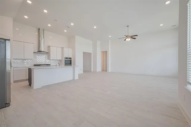 a view of kitchen with kitchen island white cabinets and stainless steel appliances
