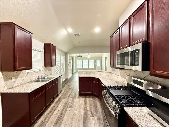 a kitchen with a stove a sink and a microwave