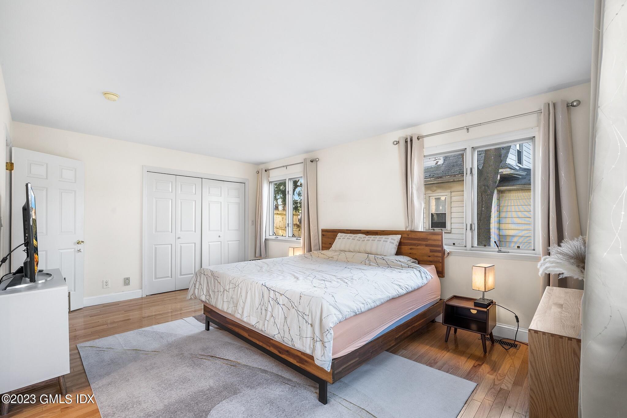 53 Bible Street, Unit 1 Cos Cob, CT 06807 - Photo 13 of 14 a bedroom with a bed table and a flat screen tv