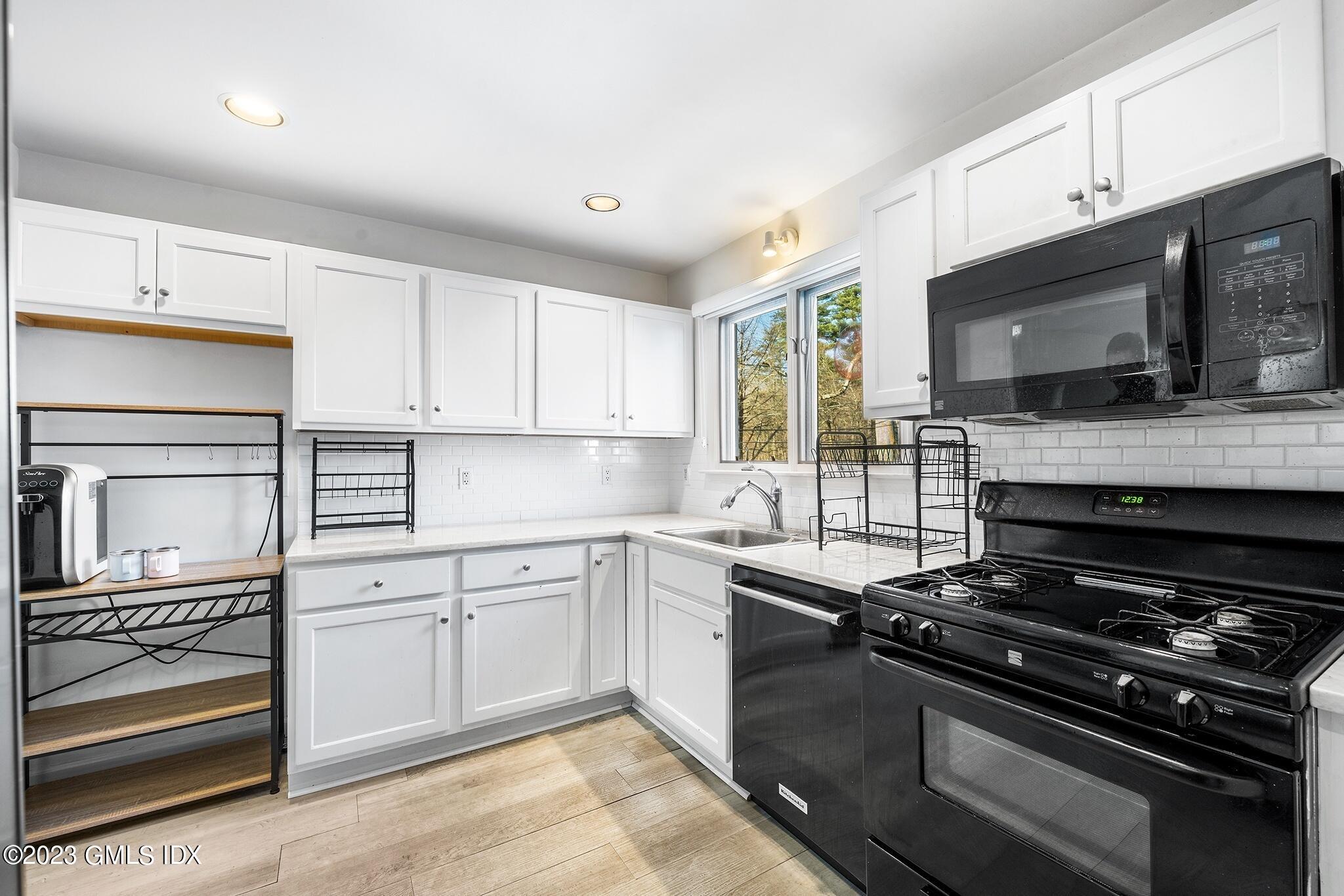 53 Bible Street, Unit 1 Cos Cob, CT 06807 - Photo 3 of 14 a kitchen with a sink stove and microwave