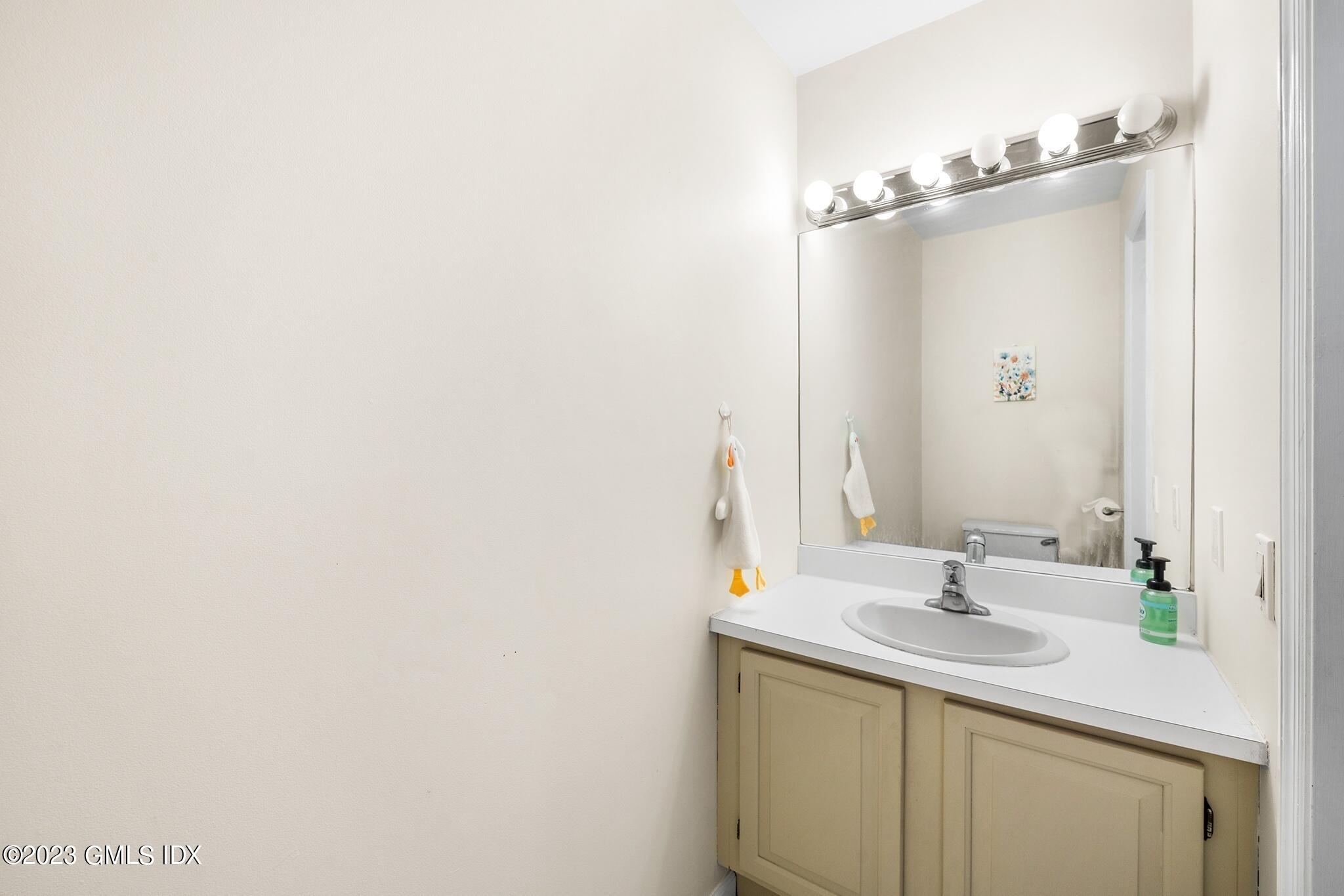 53 Bible Street, Unit 1 Cos Cob, CT 06807 - Photo 4 of 14 a bathroom with a sink and a mirror