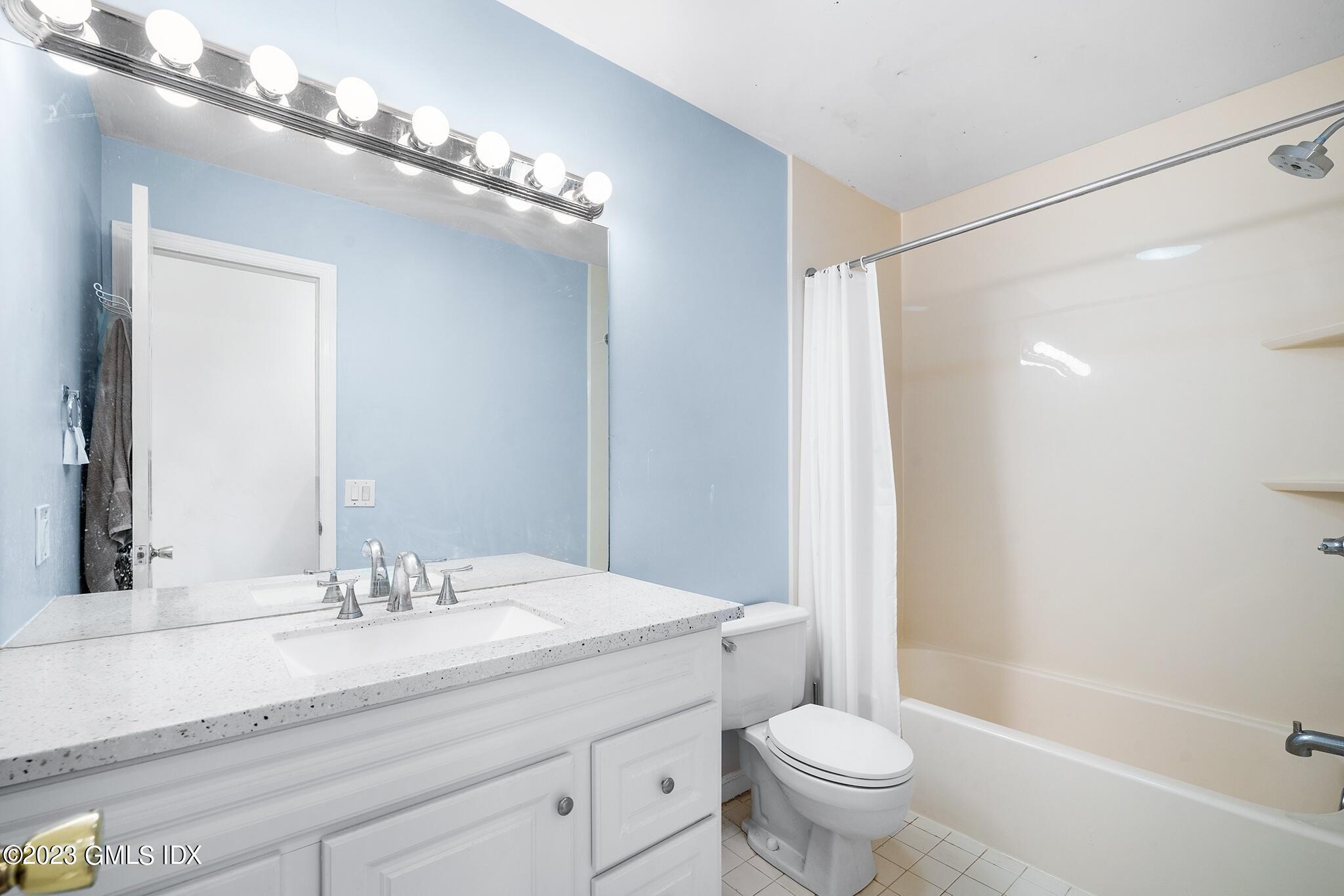 53 Bible Street, Unit 1 Cos Cob, CT 06807 - Photo 10 of 14 a bathroom with a toilet a sink and a large mirror