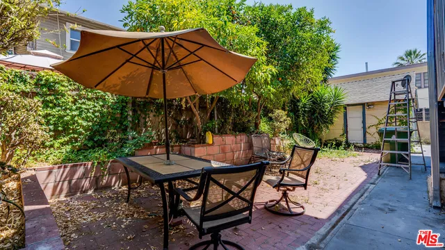 a patio with a table and chairs under an umbrella