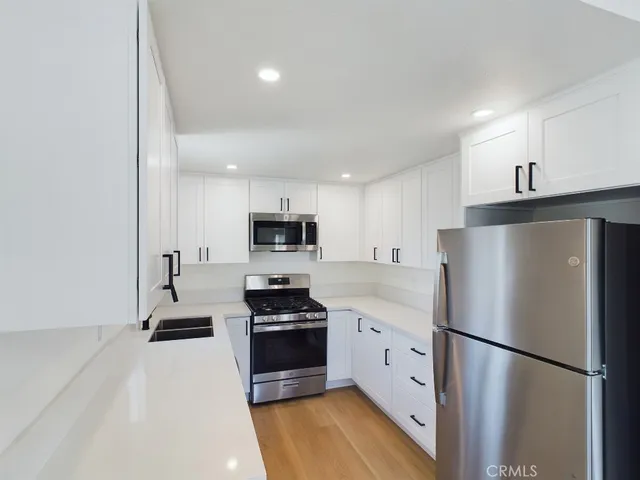 a kitchen with stainless steel appliances a refrigerator sink and stove