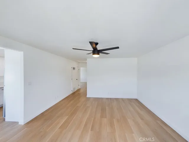 a view of a room with wooden floor and white walls
