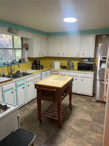 a kitchen with a sink appliances and cabinets