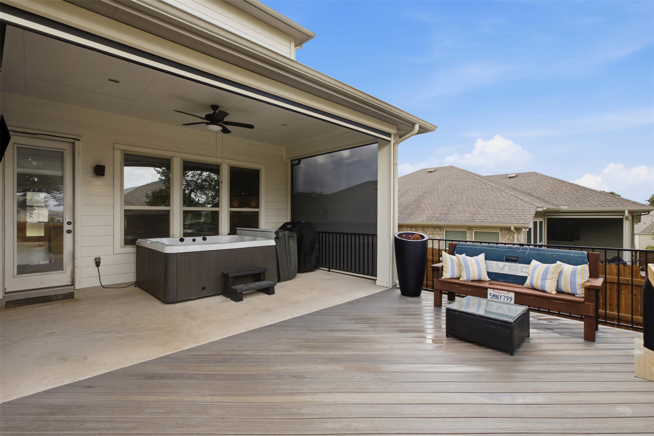 1113 Modoc Way Kyle, TX 78640 - Photo 30 of 34 An inviting outdoor deck features a hot tub, ceiling fan, and seating area for ultimate relaxation.