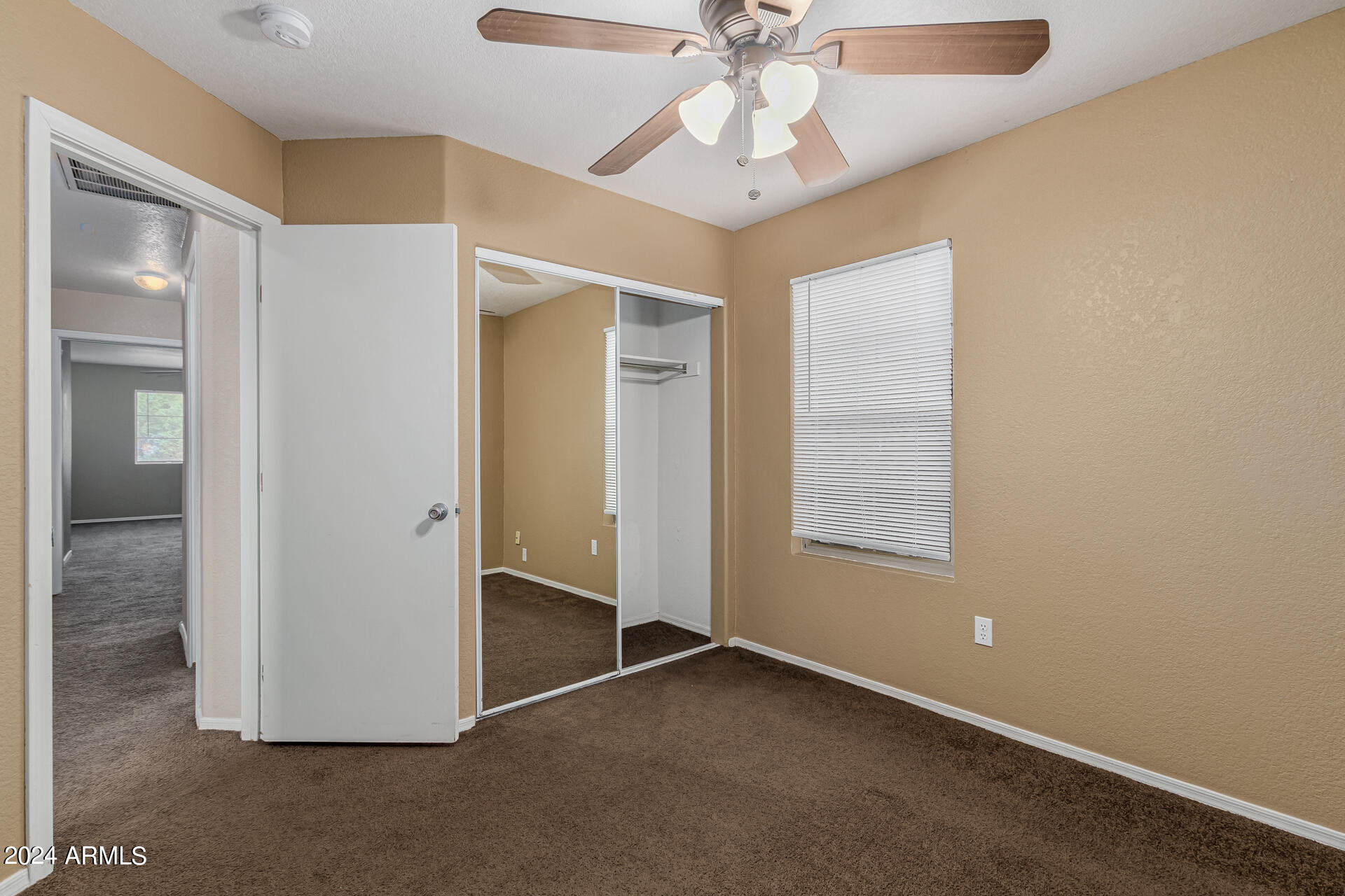 1371 South Boulder Street, Unit A Gilbert, AZ 85296 - Photo 29 of 43 an empty room with a chandelier fan and windows
