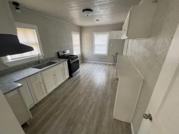 a kitchen with granite countertop a sink and a stove top oven
