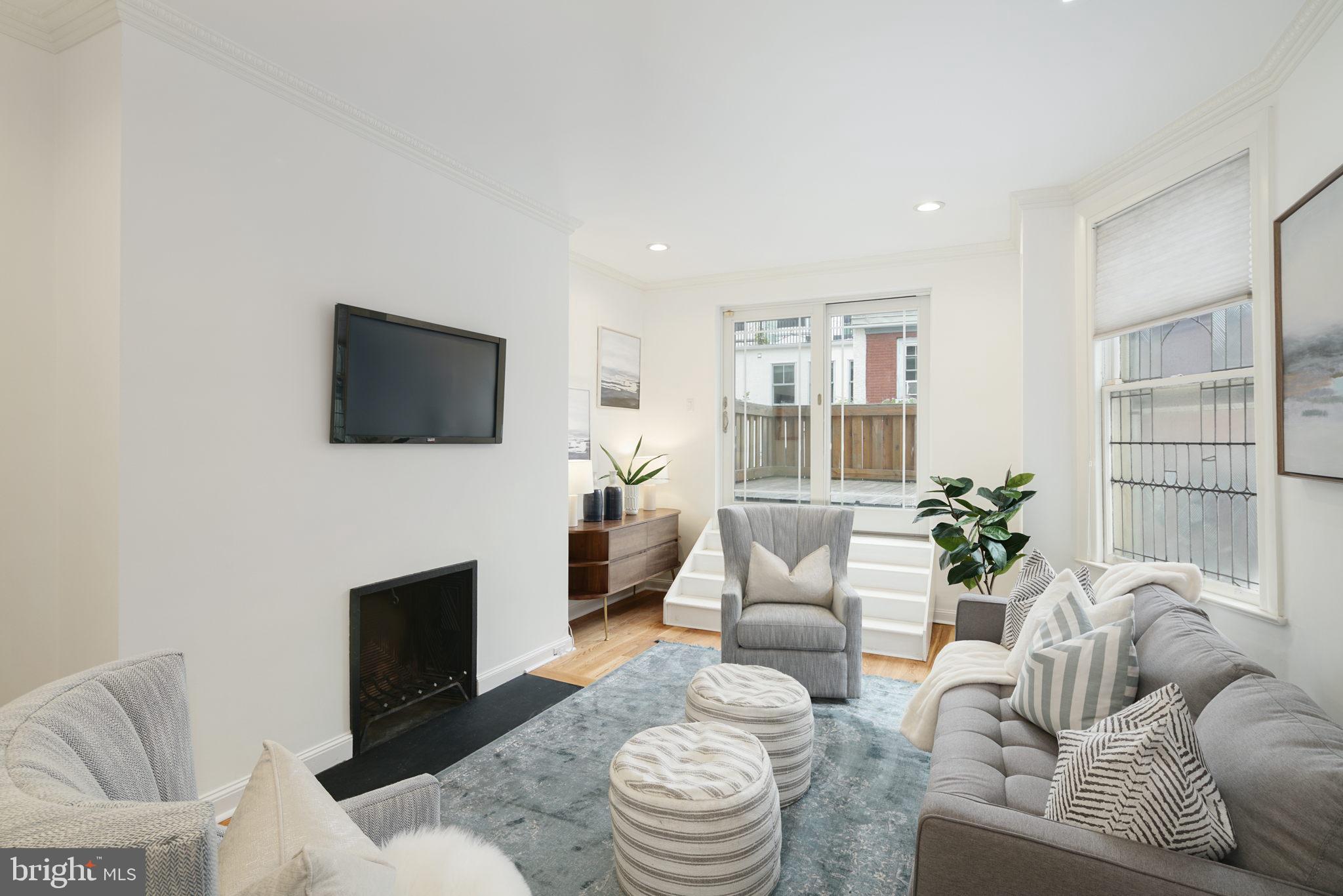 2028 Locust Street Philadelphia, PA 19103 - Photo 18 of 31 a living room with furniture a fireplace and a flat screen tv