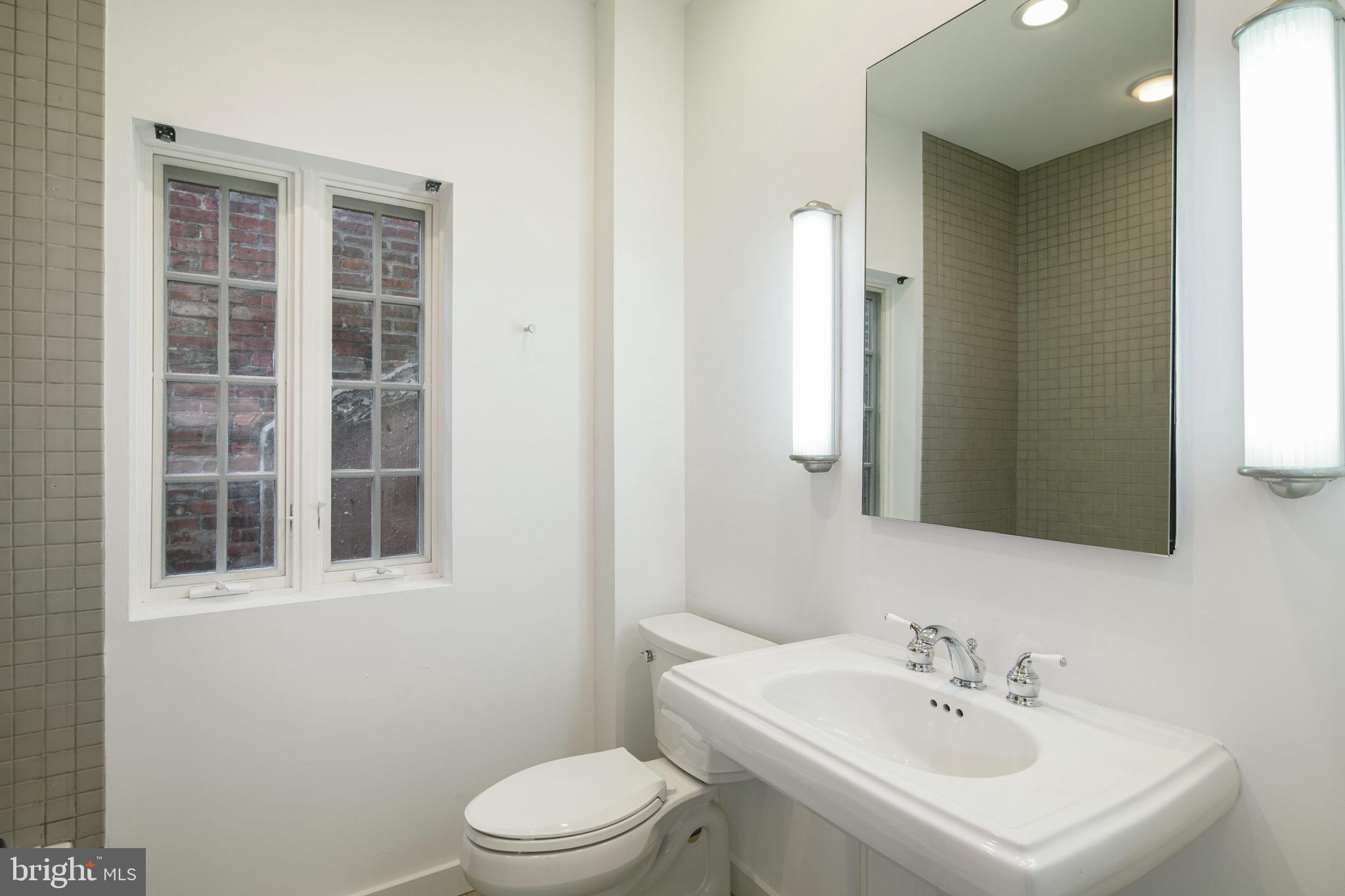 2028 Locust Street Philadelphia, PA 19103 - Photo 23 of 31 a bathroom with a sink a toilet and a mirror