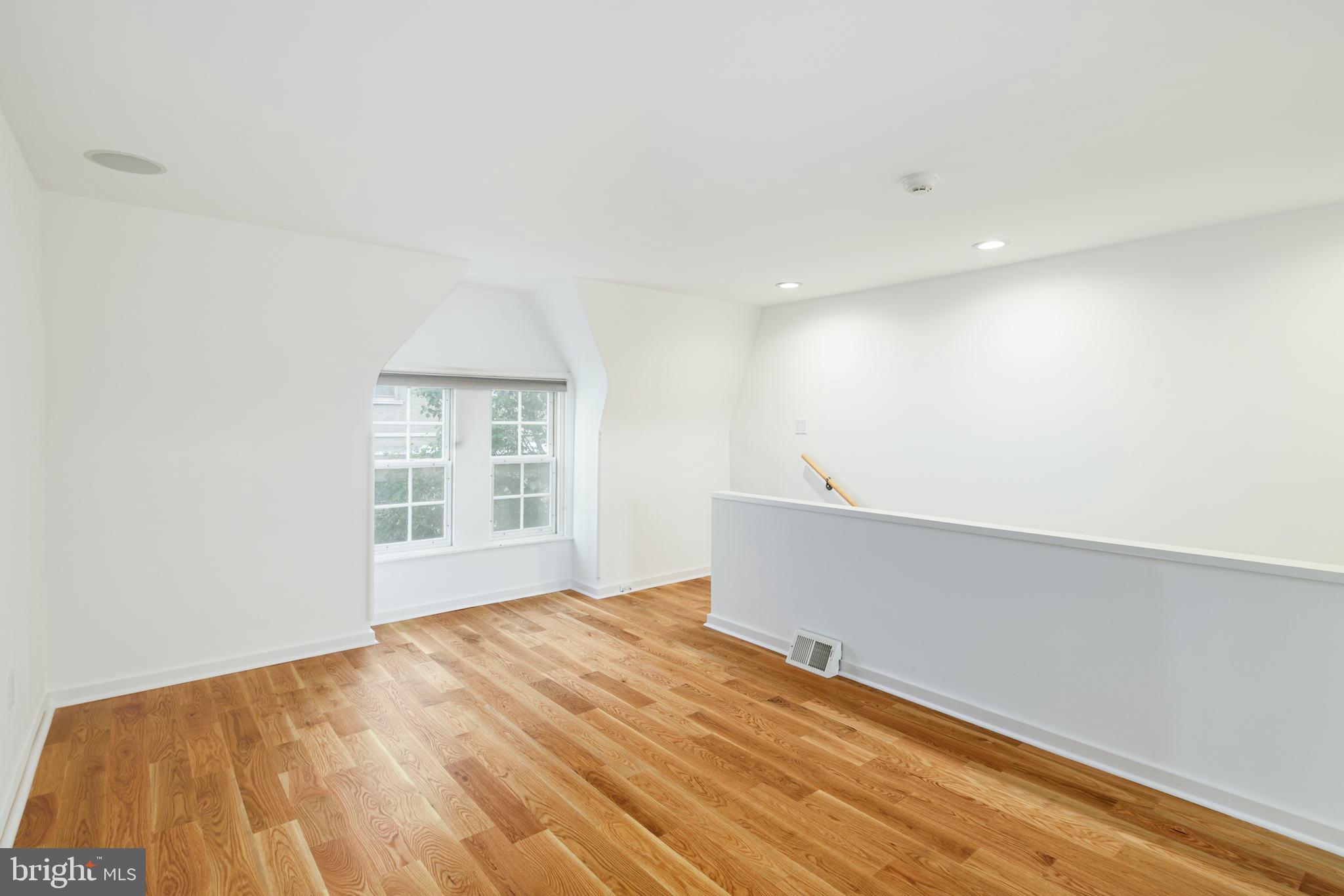 2028 Locust Street Philadelphia, PA 19103 - Photo 25 of 31 a view of an empty room with wooden floor and a window