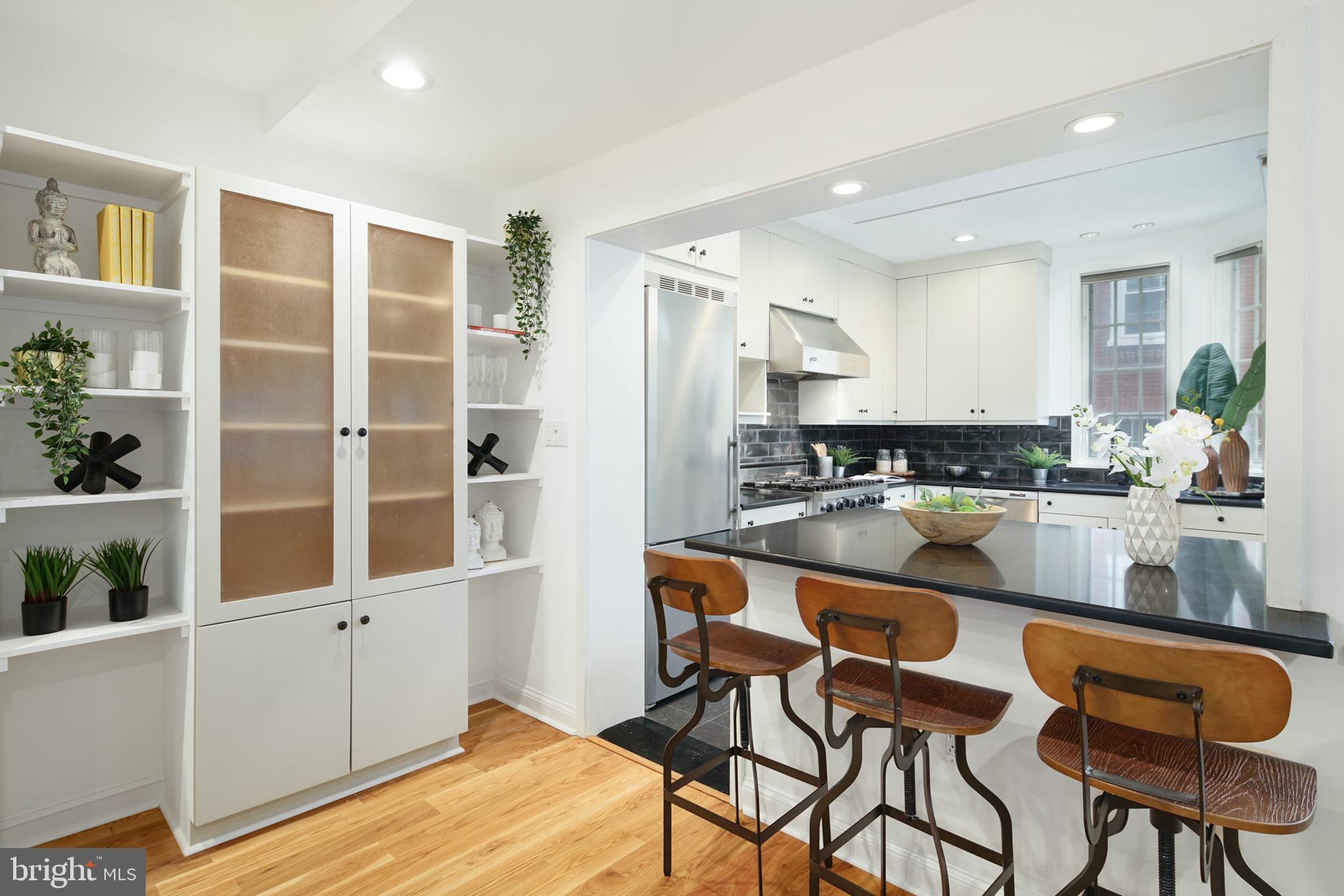 2028 Locust Street Philadelphia, PA 19103 - Photo 8 of 31 a kitchen with stainless steel appliances granite countertop a refrigerator and wooden cabinets