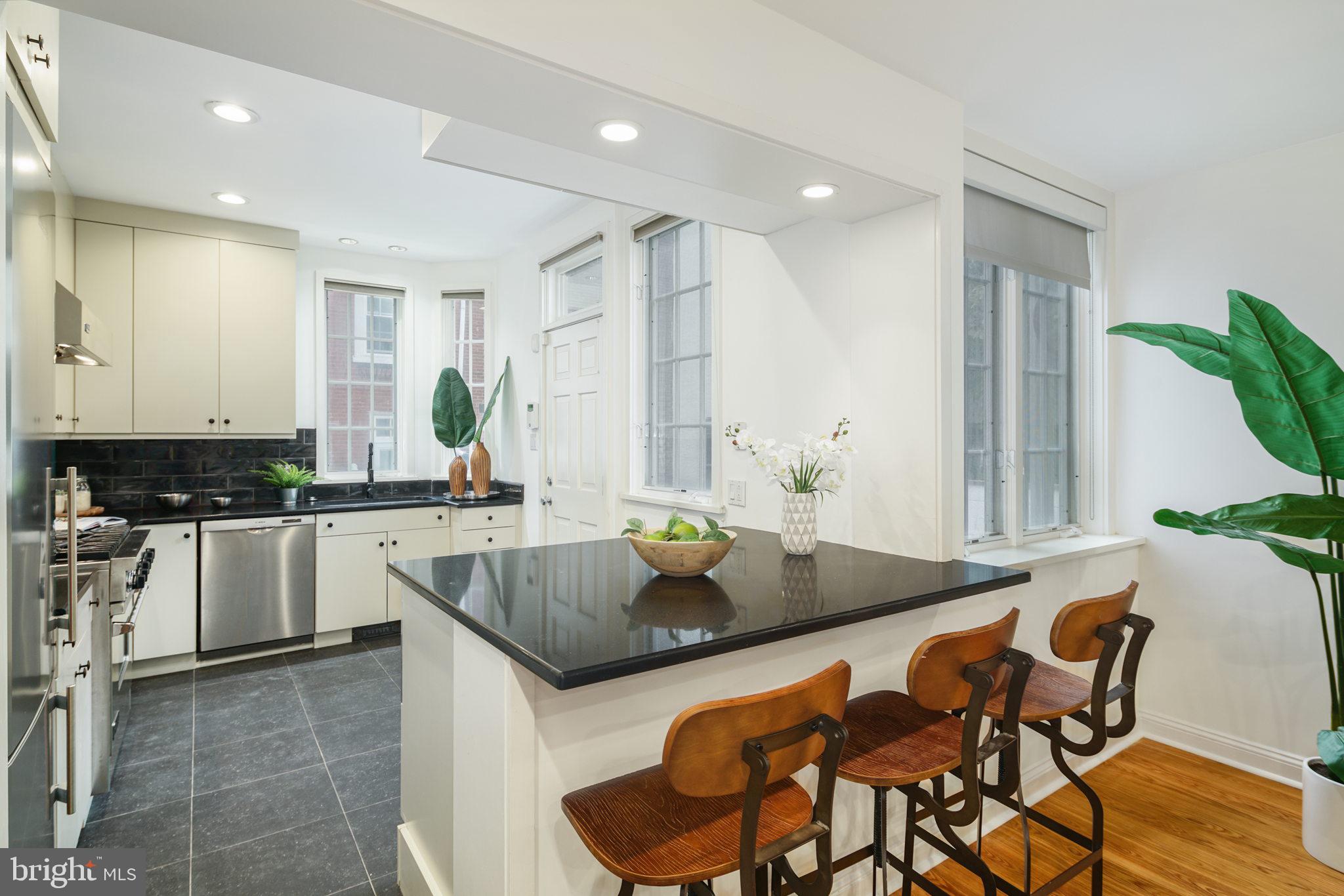 2028 Locust Street Philadelphia, PA 19103 - Photo 9 of 31 a kitchen with a dining table chairs and white cabinets