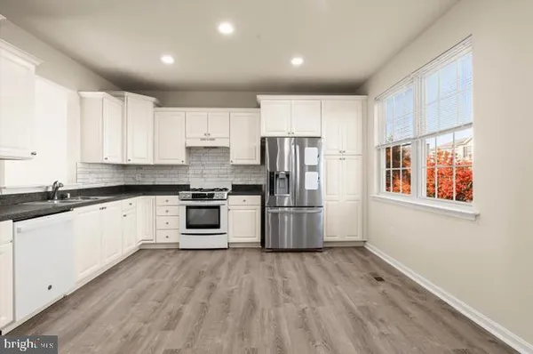 a kitchen with stainless steel appliances a refrigerator and a stove top oven
