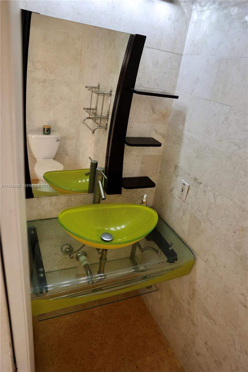 11049 Southwest 152nd Court Miami, FL 33196 - Photo 12 of 57 a bathroom with a sink toilet and mirror