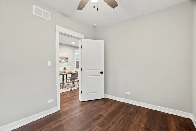a view of a room with wooden floor and a kitchen