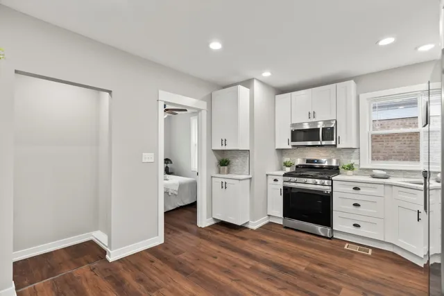 a kitchen with stainless steel appliances a stove top oven and a refrigerator