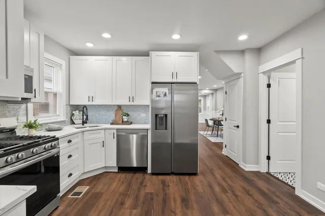 a kitchen with stainless steel appliances a refrigerator sink and cabinets