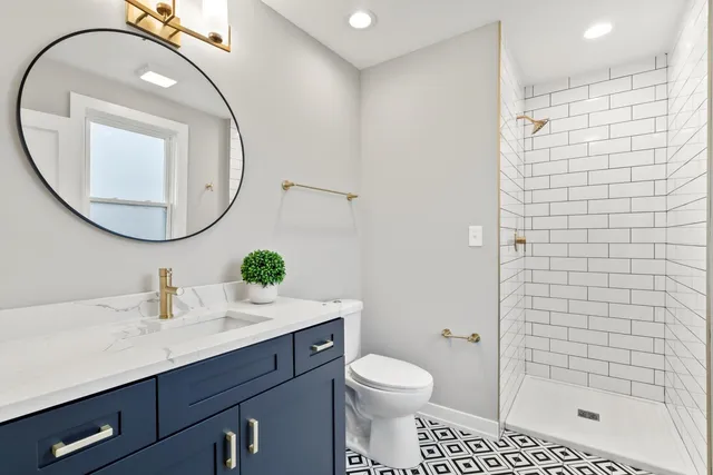 a bathroom with a sink a toilet and shower