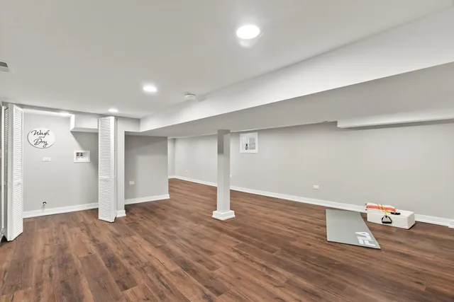 an empty room with wooden floor and entrance