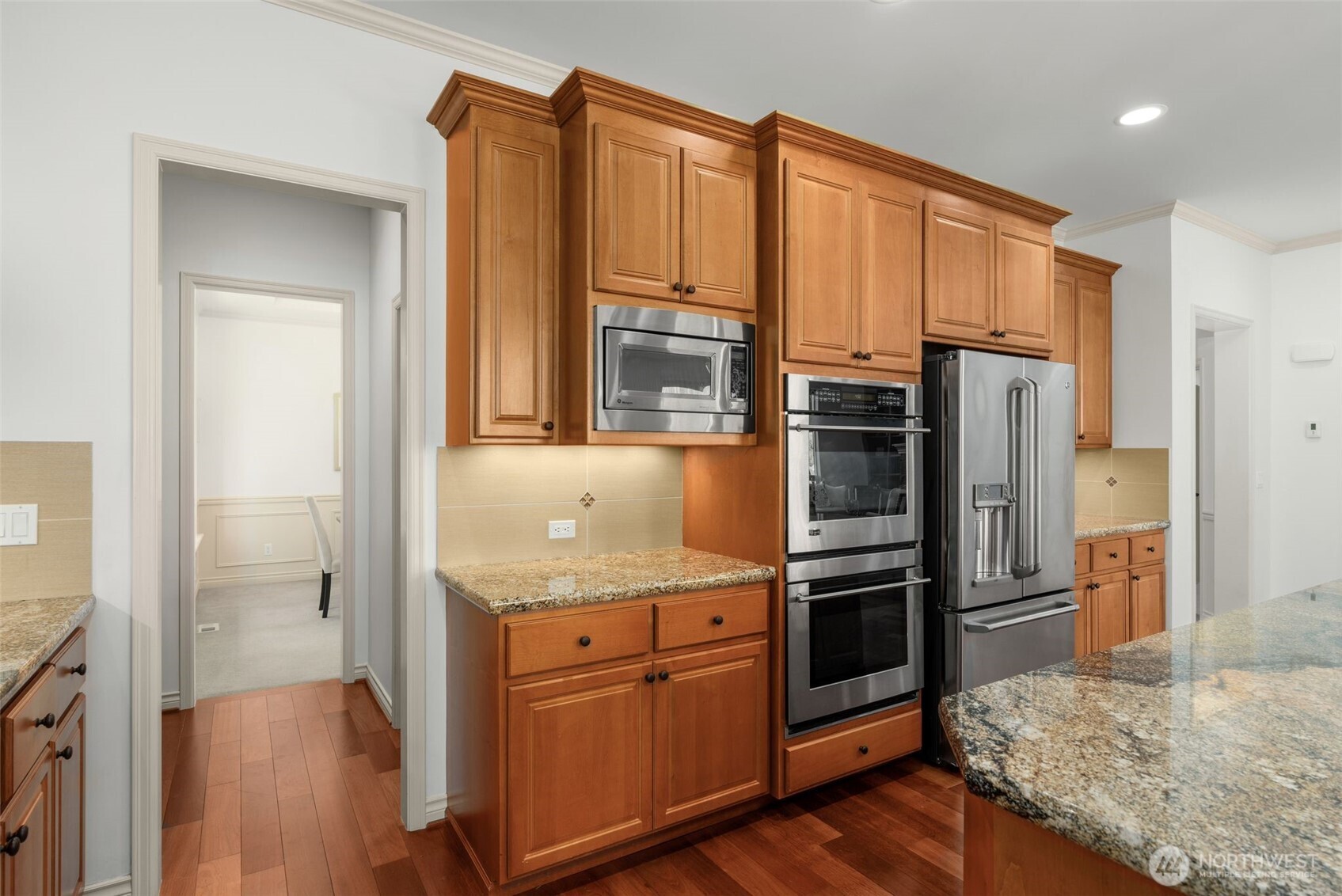 2022 240th Place Southeast Bothell, WA 98021 - Photo 16 of 40 a kitchen with stainless steel appliances granite countertop a refrigerator a stove and a sink with wooden floor